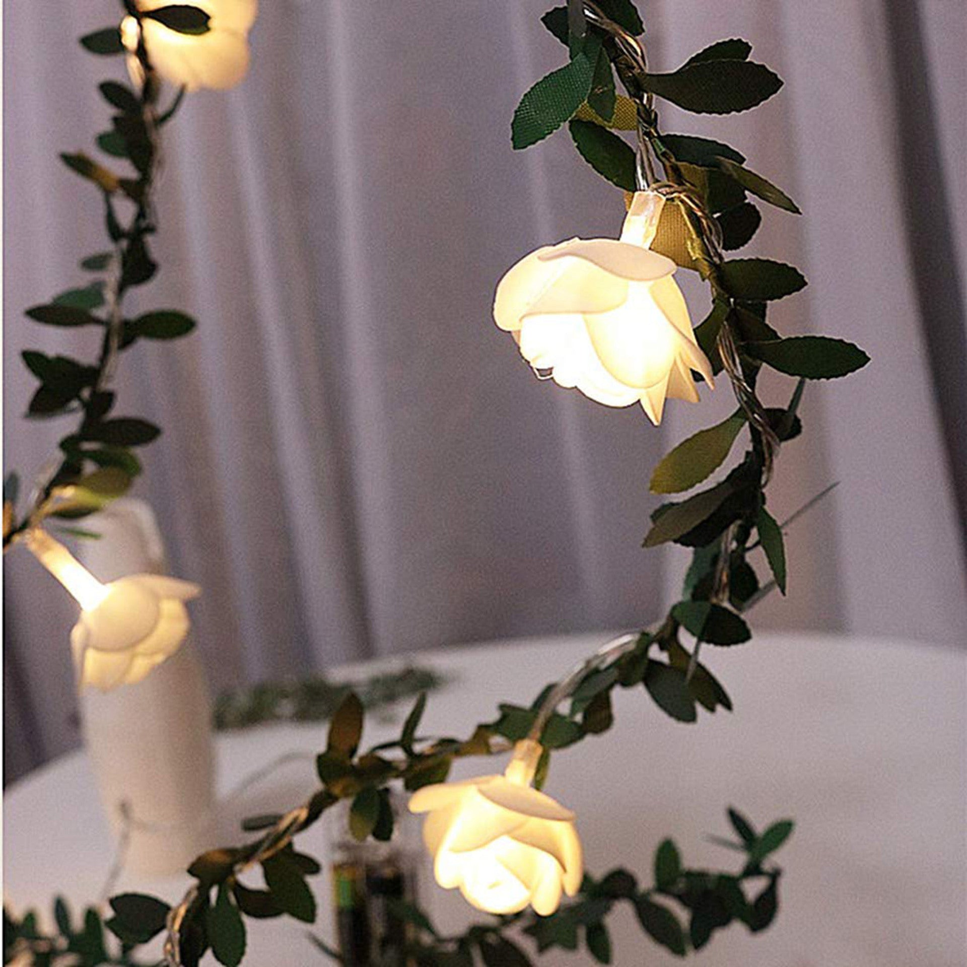 Guirlande lumineuse LED roses et lierre Nesty - Guirlande suspendue devant un rideau clair, roses allumées