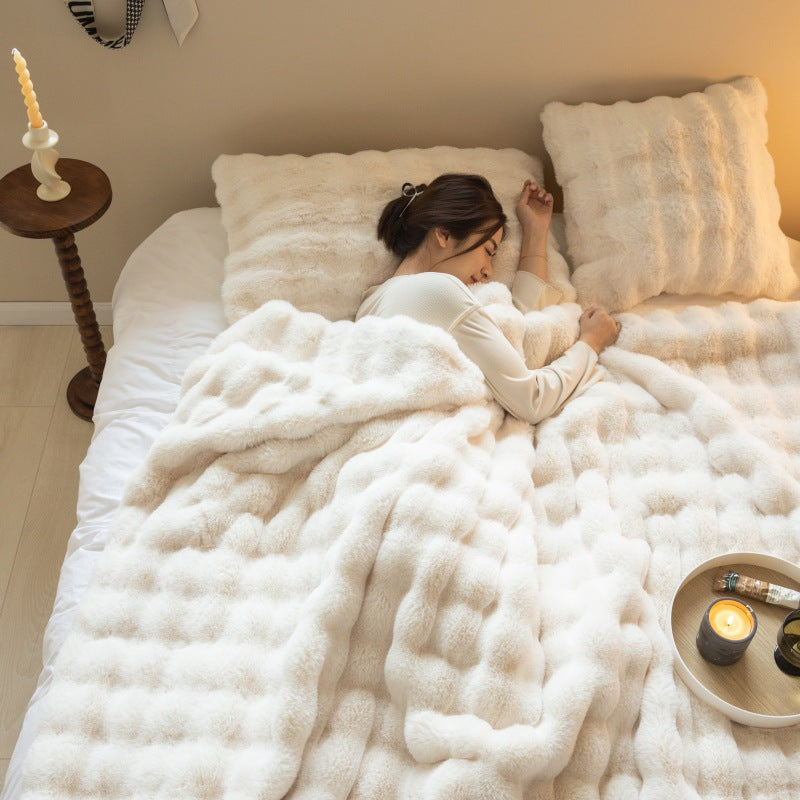 Plaid en velours rabbit Nesty - Coloris écru, personne endormie dans un lit avec bougies sur table de chevet