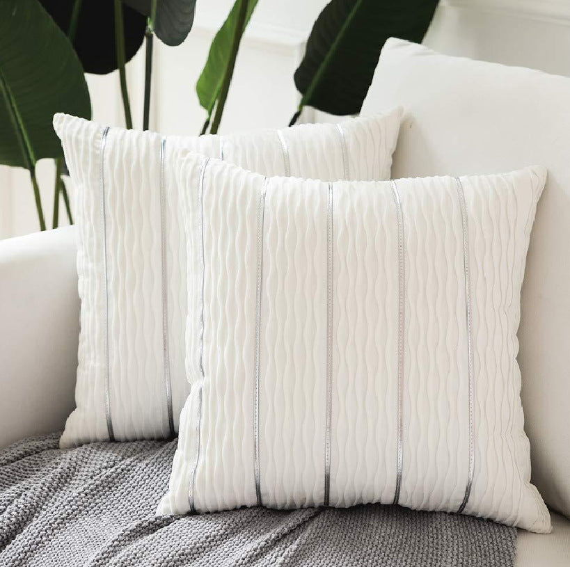 Housse de coussin en velours rayé Nesty - Deux coussins blancs à rayures argentées sur un fauteuil clair