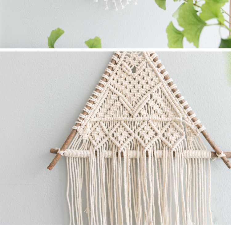 Suspension murale en macramé Nesty - Gros plan du tressage écru à motifs losanges sur branche de bois