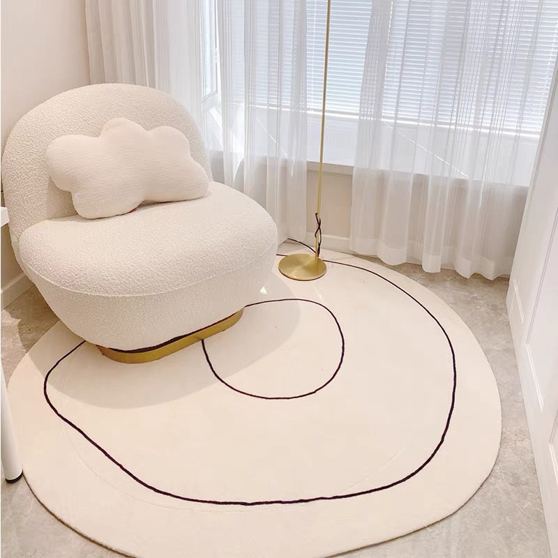 Tapis rond effet cachemire crème Nesty - Motif à ligne noire fine, fauteuil bouclé blanc avec coussin nuage et lampadaire doré
