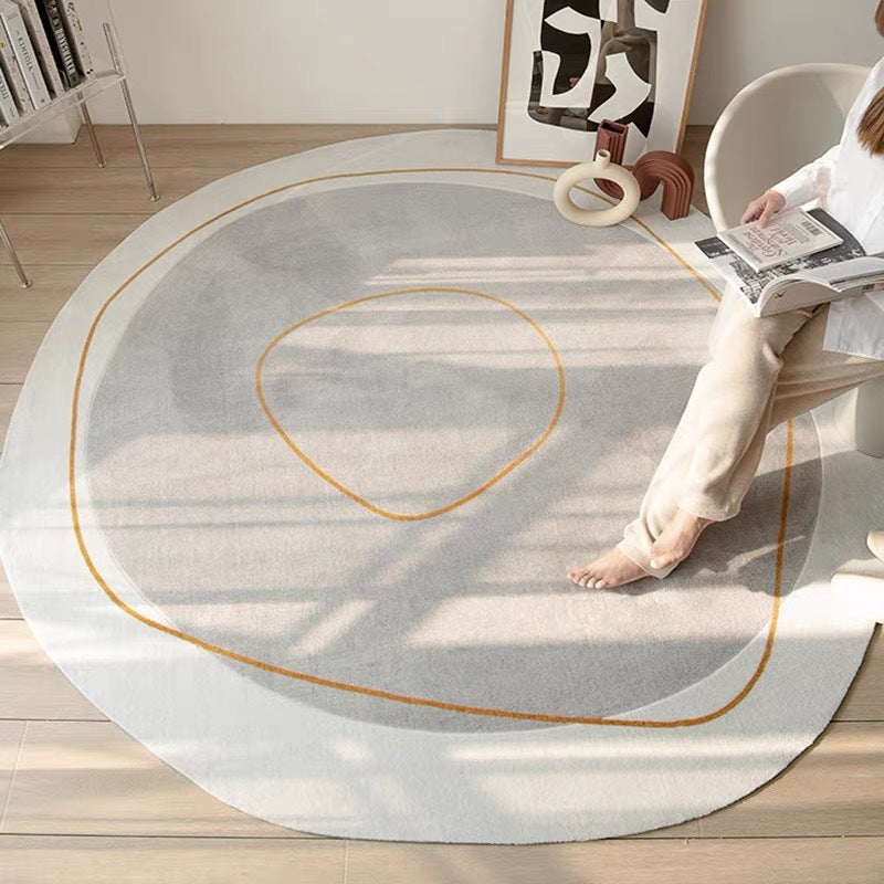 Tapis rond effet cachemire crème Nesty - Vue rapprochée du motif à lignes dorées près du fauteuil en osier