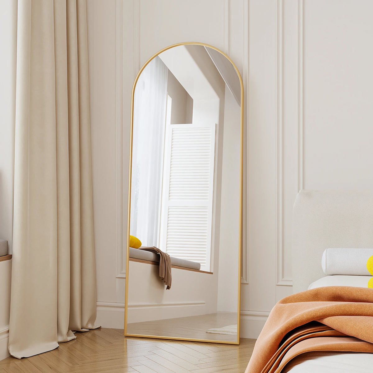Miroir psyché cintré doré Nesty - Sur pied, posé en appui dans une chambre près de rideaux et d'un lit à plaid orange