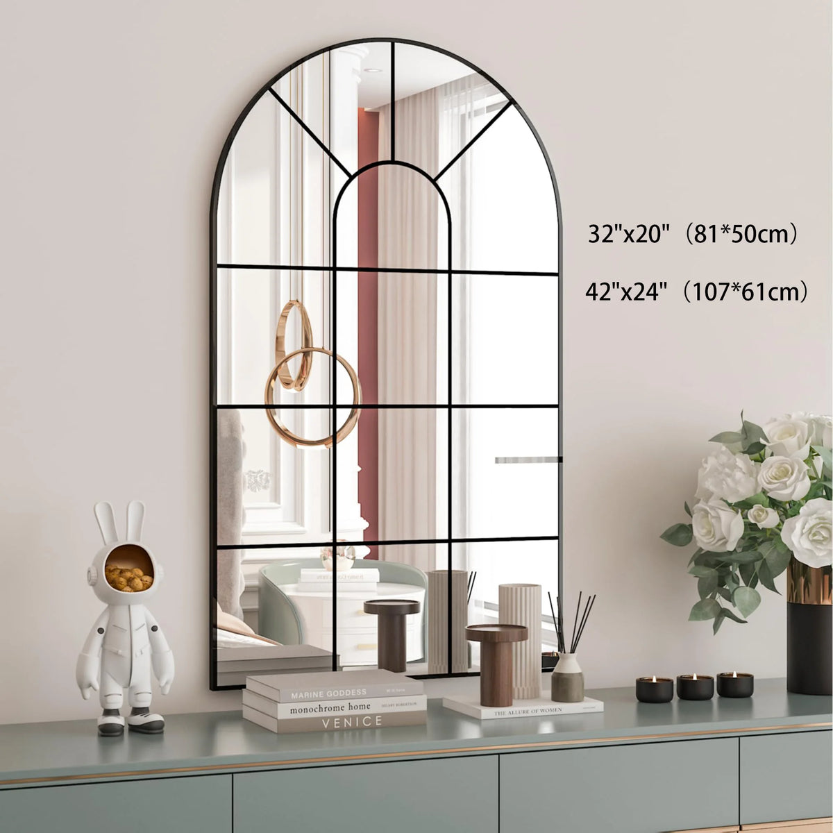 Miroir fenêtre cintré Nesty - Cadre noir rustique, schéma des deux formats disponibles, 81x50 cm et 107x61 cm, sur une commode avec figurines décoratives