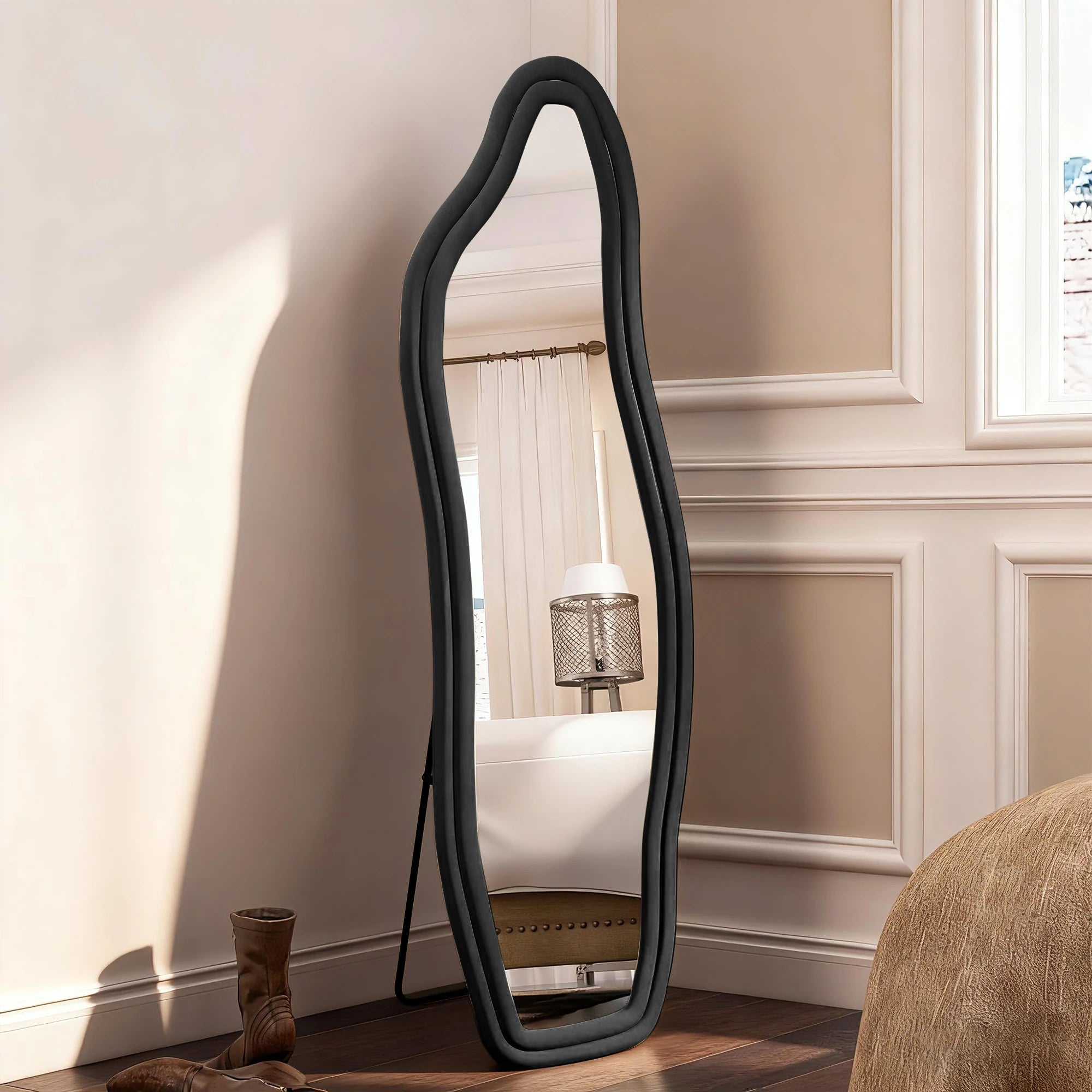 Miroir psyché ondulé Nesty - Cadre noir velours, posé au sol, reflet d'un rideau et d'une lampe