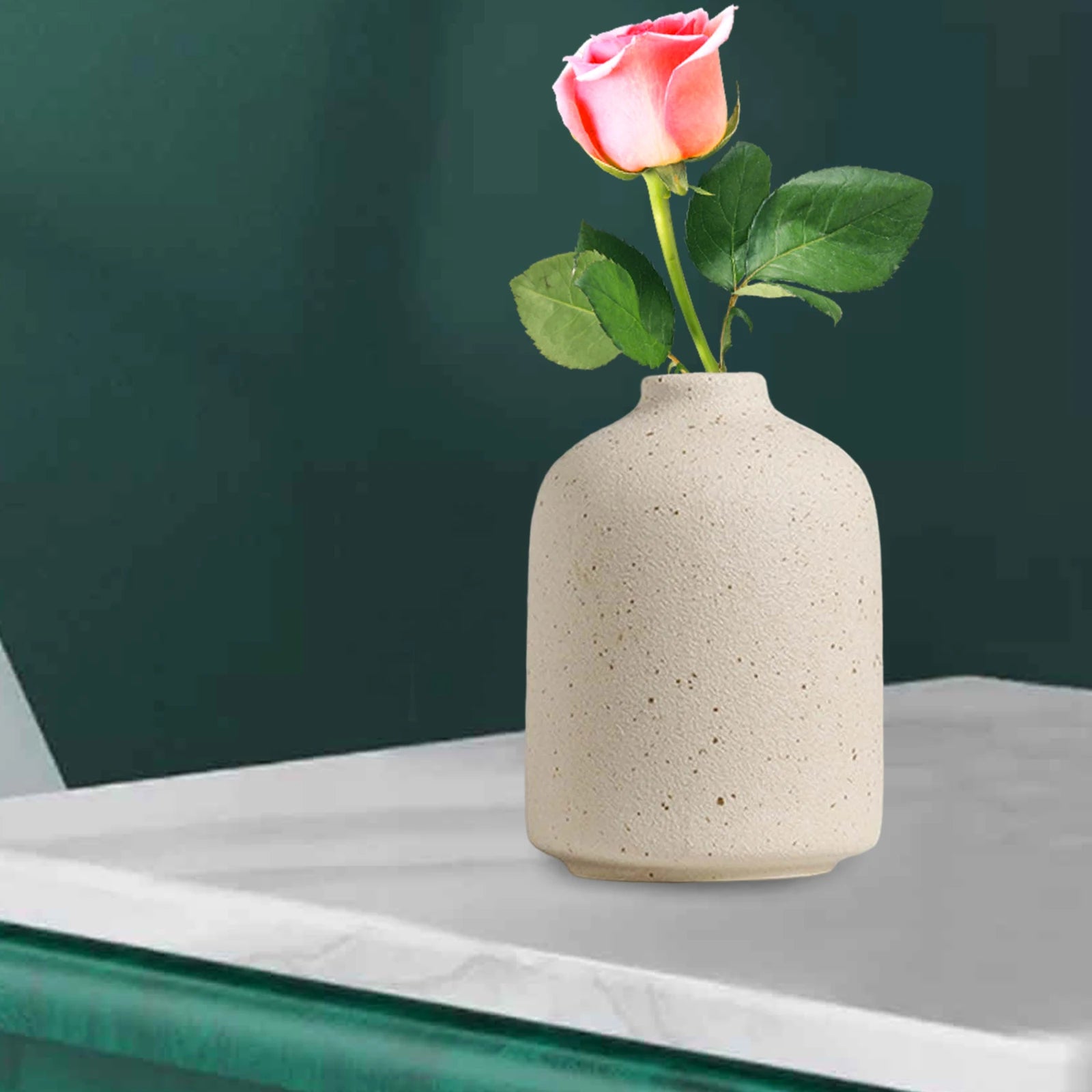Vase en céramique bohème Nesty - Forme cylindrique beige avec rose rose posée sur console, fond vert foncé