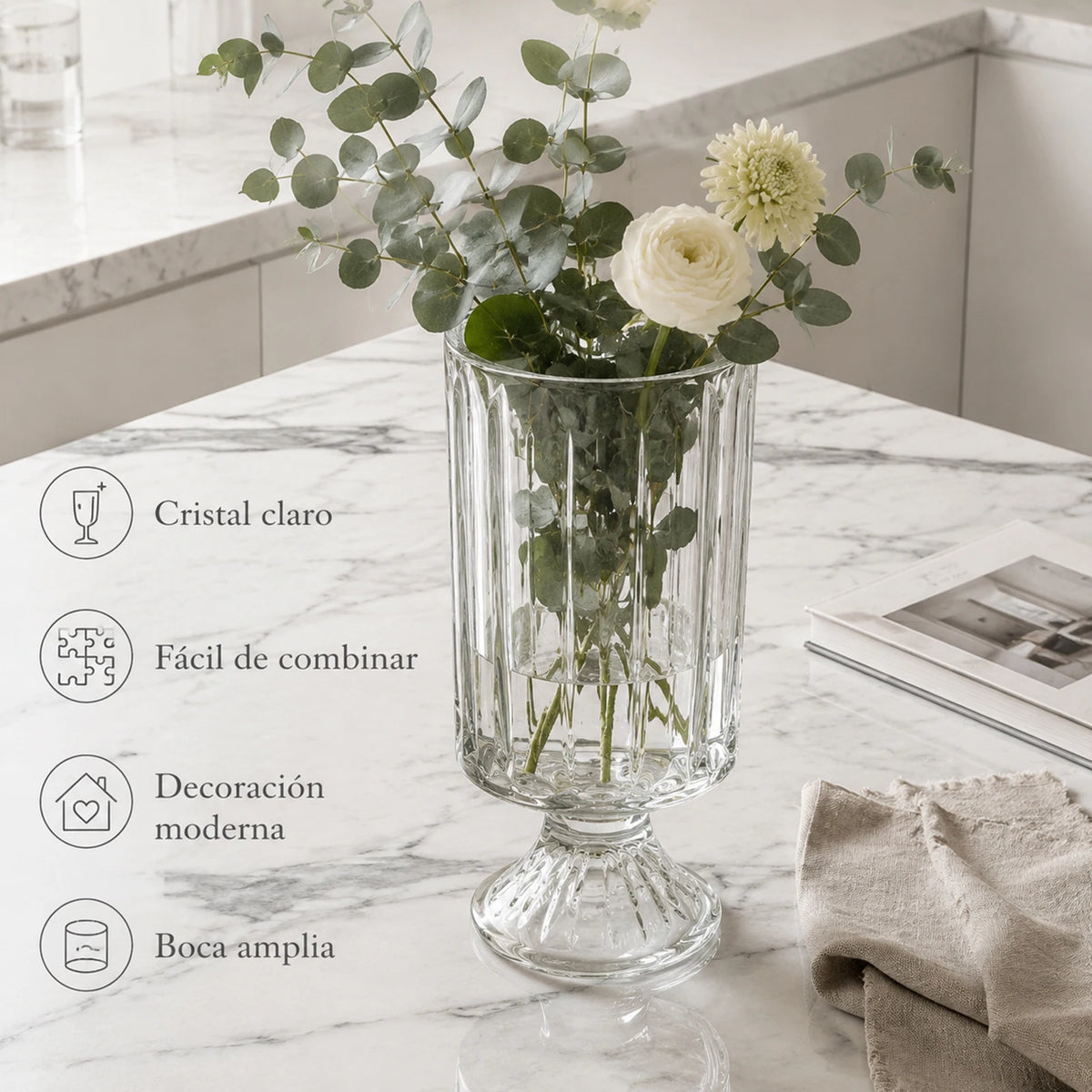Vase en verre transparent 23 cm, socle piédestal vintage Nesty, garni d'eucalyptus et de roses blanches, sur plan de travail en marbre, fiche produit en espagnol