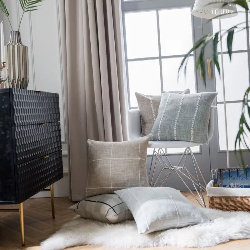 Housse de coussin en coton et lin, rouge écarlate, matière épaisse Nesty, housses de coussin à carreaux beige, taupe et gris clair posées sur chaise et tapis moelleux, devant une commode noire texturée