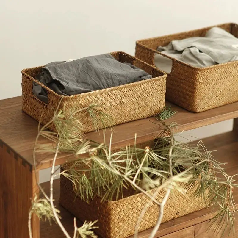 Panier tressé en fibre naturelle Nesty - Deux tailles avec linge, posées sur une table en bois