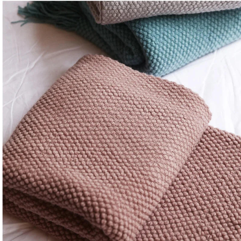 Plaid en maille chunky à franges, tricot épais pour canapé Nesty, trois plaids en maille chunky pliés, coloris vert d'eau, taupe et rose poudré, gros plan sur la texture perlée