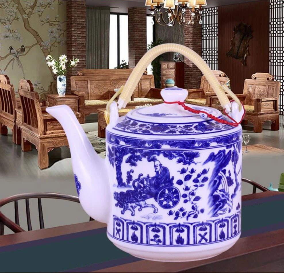Théière en porcelaine bleu et blanc, grande capacité 2L Nesty, motif paysage montagneux chinois, anse en rotin, en situation dans un salon chinois traditionnel avec lustre et fauteuils en bois