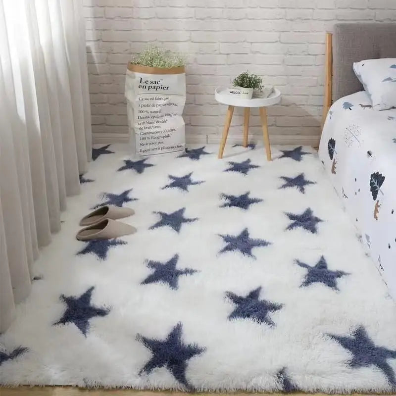 Tapis blanc à motifs d'étoiles bleu marine, posé au sol dans une chambre près d'un lit et d'une paire de chaussons.