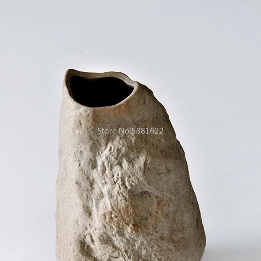 Vase en céramique et pierre, forme organique moderne Nesty, gros plan sur un vase en forme de pierre brute, ouverture sombre visible, fond blanc