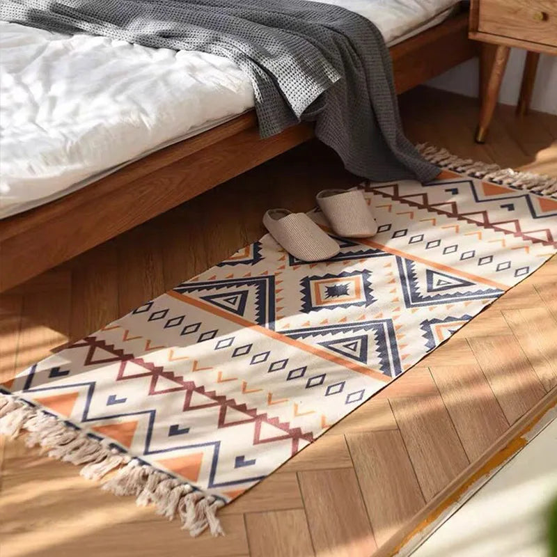 Tapis vintage à carreaux — coton, esprit bohème - Nesty, vue rapprochée en angle posé au pied d'un lit avec un plaid gris