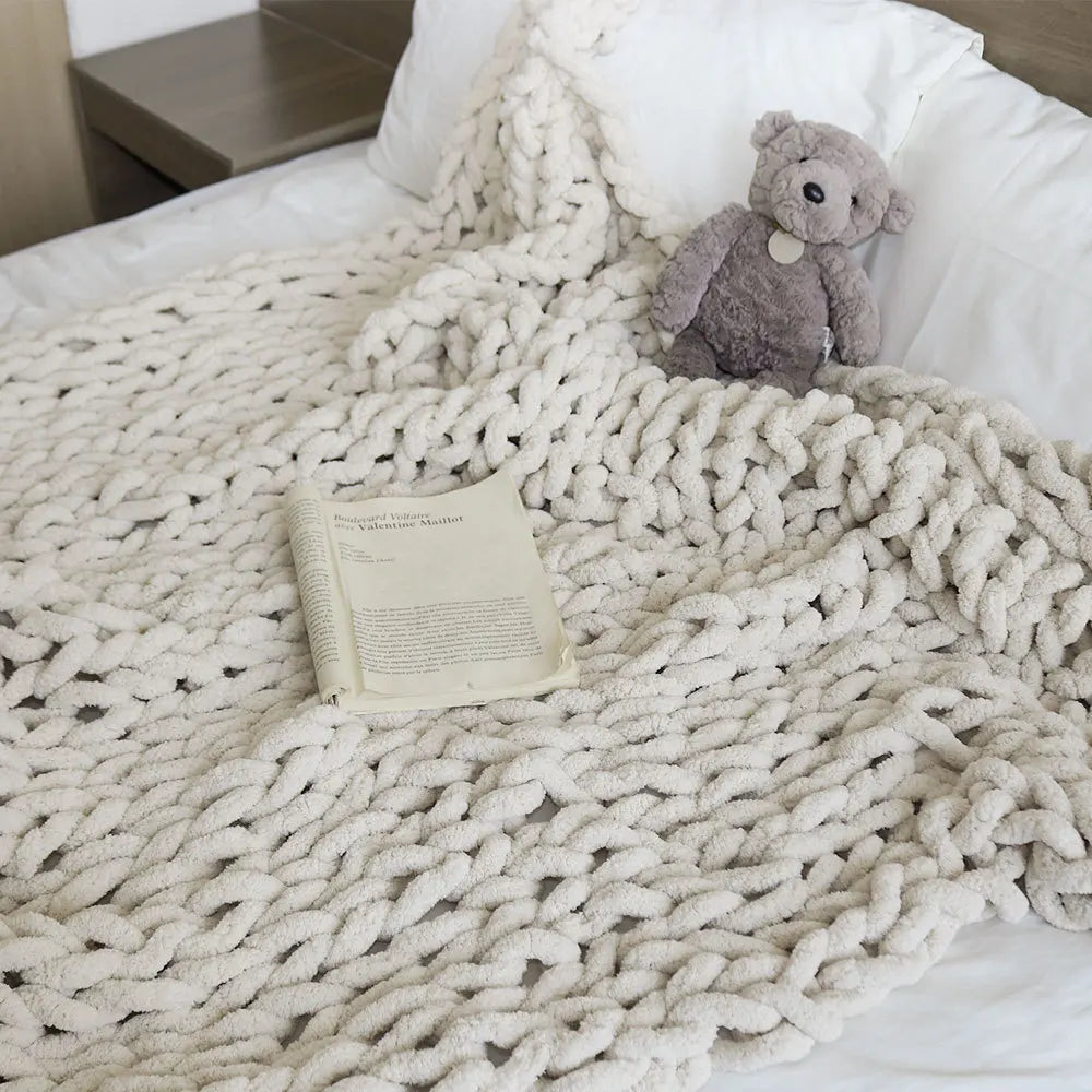 Plaid tout doux Nesty - Coloris crème à grosses mailles, sur lit avec livre ouvert et peluche ours