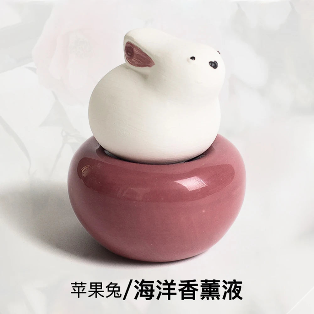Diffuseur de parfum sans flamme forme animale Nesty - Petit lapin blanc sur socle rose foncé, parfum ocean