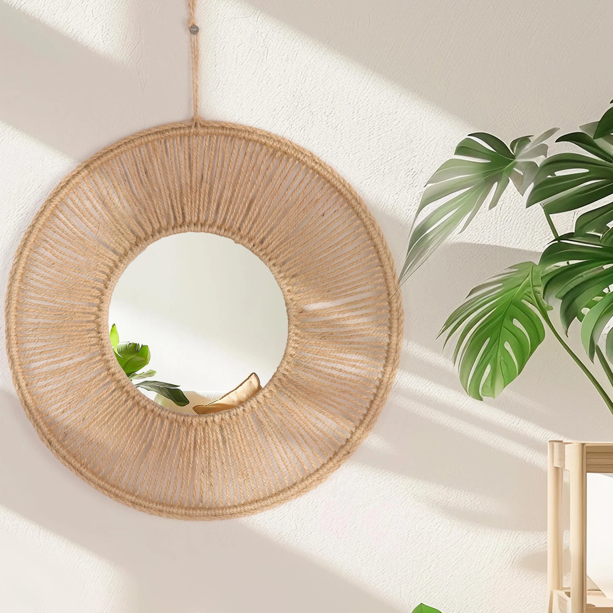 Miroir mural rond enroulé de corde de raphia naturel, suspendu sur mur ensoleillé avec feuille de monstera - Nesty