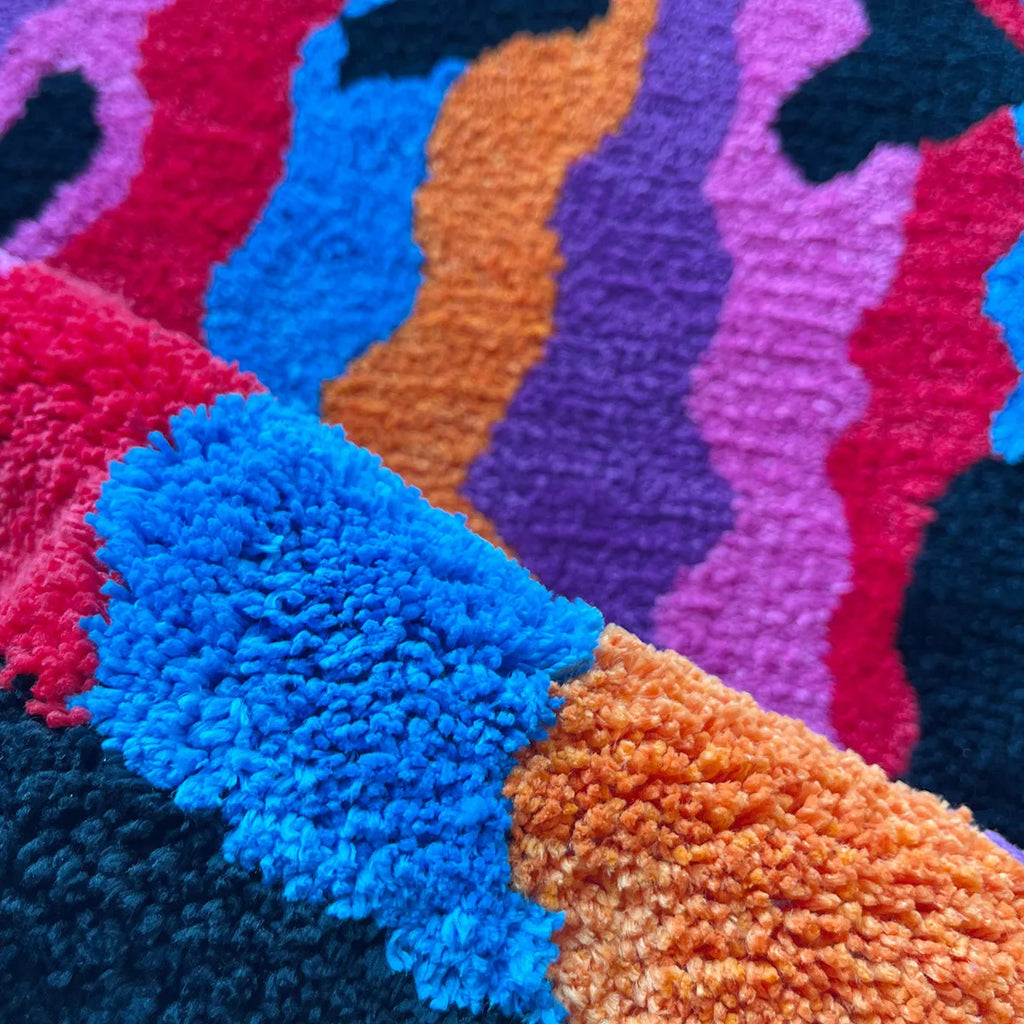 Tapis tufté à motif tourbillon Nesty - Fabrication artisanale, gros plan sur les touffes de laine multicolores