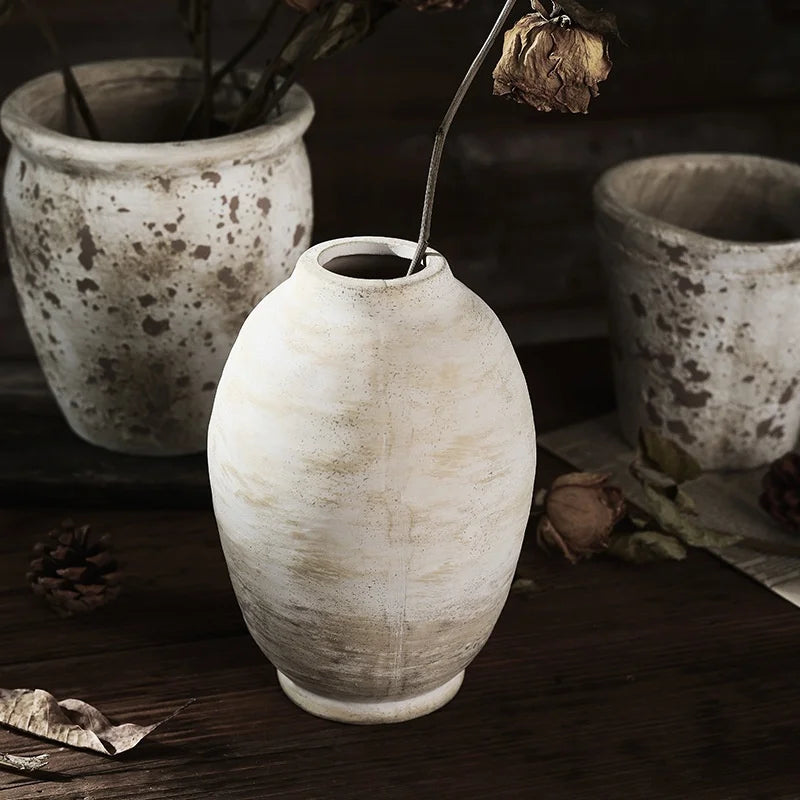 Vase céramique artisanal, style rétro fait main - Nesty - Vase ovoïde blanc patiné avec une tige de rose séchée, entouré de deux pots texturés en arrière-plan