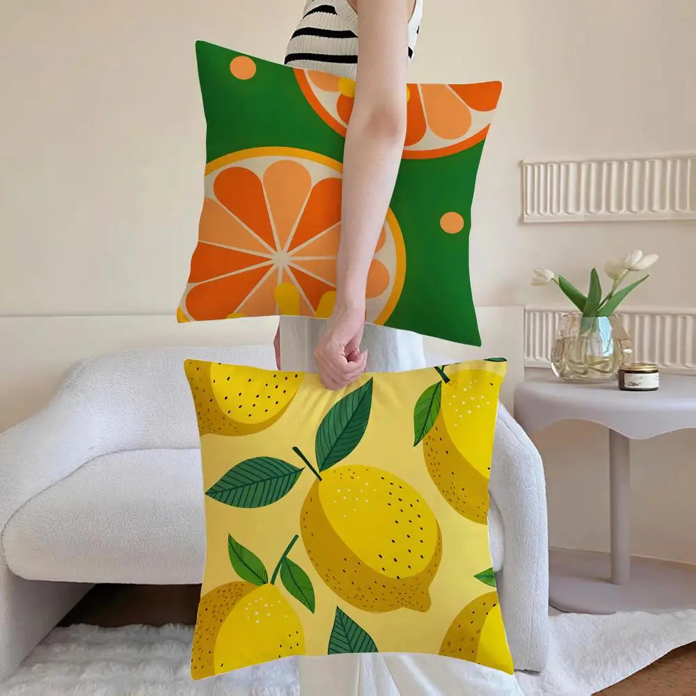 Housse de coussin en lin imitation, jaune citron, style léger Nesty, femme tenant deux housses de coussin à motif orange sur fond vert et motif citrons sur fond jaune, posées sur canapé blanc