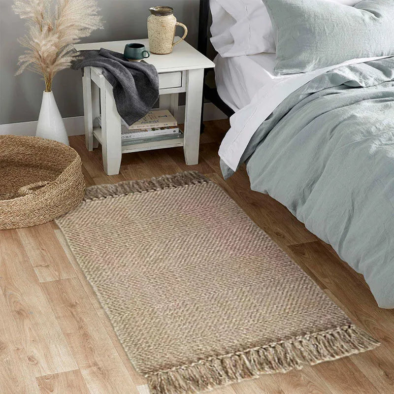 Tapis en coton et lin à rayures — style nordique - Nesty, coloris beige chevrons à franges, au pied d'un lit avec panier en jonc de mer