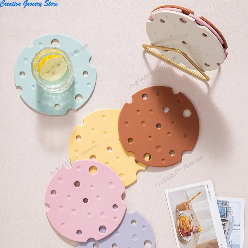 Dessous de plat en silicone forme fromage en six coloris pastel, empilés et à plat, avec présentoir doré - Nesty