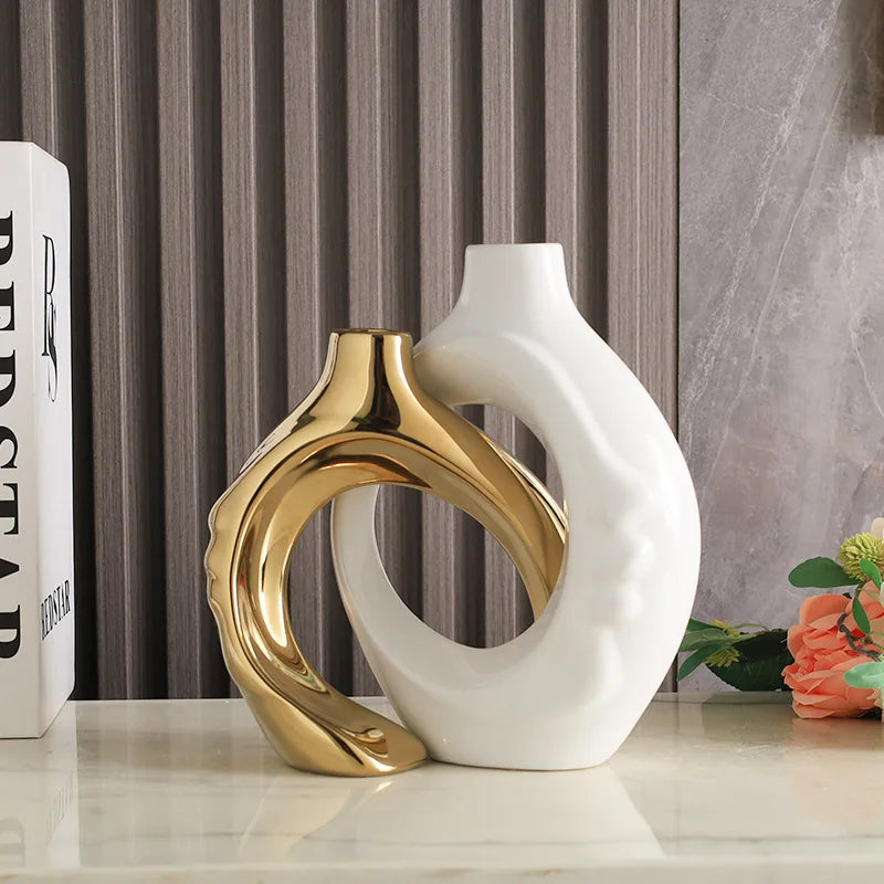 Vase en poterie Nesty - Coloris doré et blanc entrelacés, près d'un livre et de fleurs oranges