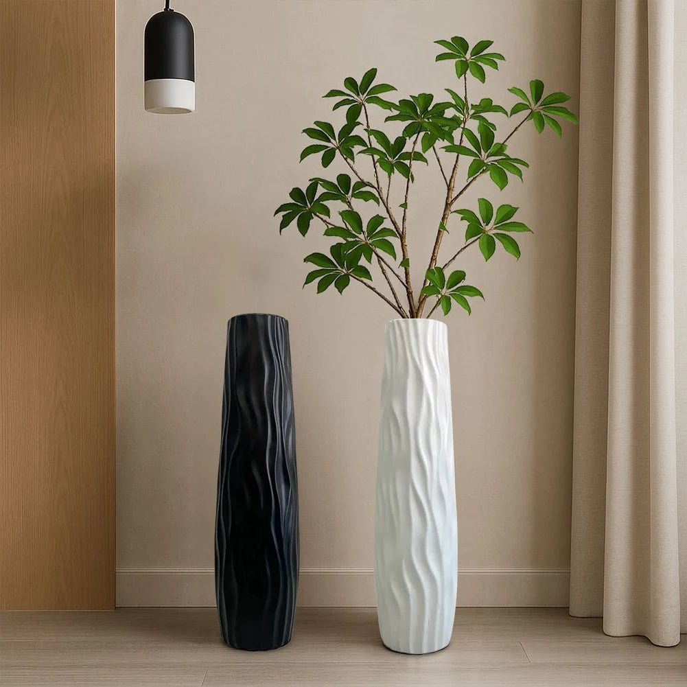 Vase sol texturé grand format Nesty - Modèles noir et blanc côte à côte avec plante verte, devant un rideau beige