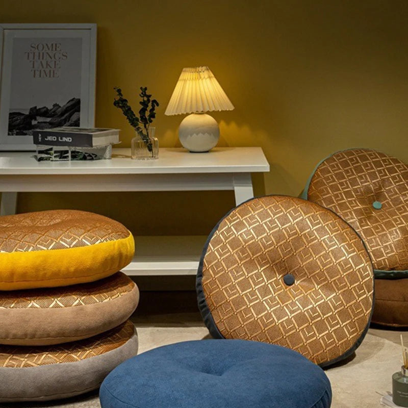 Coussin de sol rond en lin, esprit tatami, pour méditation Nesty, galettes de sol rondes matelassées à motif tressé doré, coloris jaune moutarde, taupe, gris et bleu, empilées près d'une console et lampe