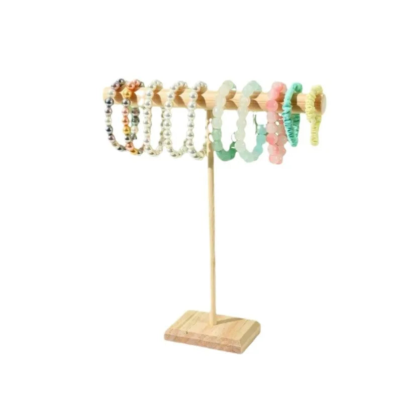 Présentoir en bois pour bijoux Nesty - Présentoir en T avec bracelets de perles colorées sur fond blanc