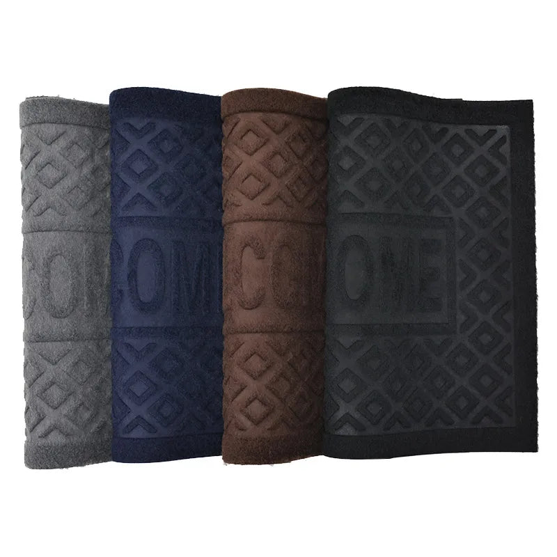 Quatre paillassons en caoutchouc enroulés debout, coloris gris, bleu marine, marron et noir, motif 'Welcome' gravé - Nesty