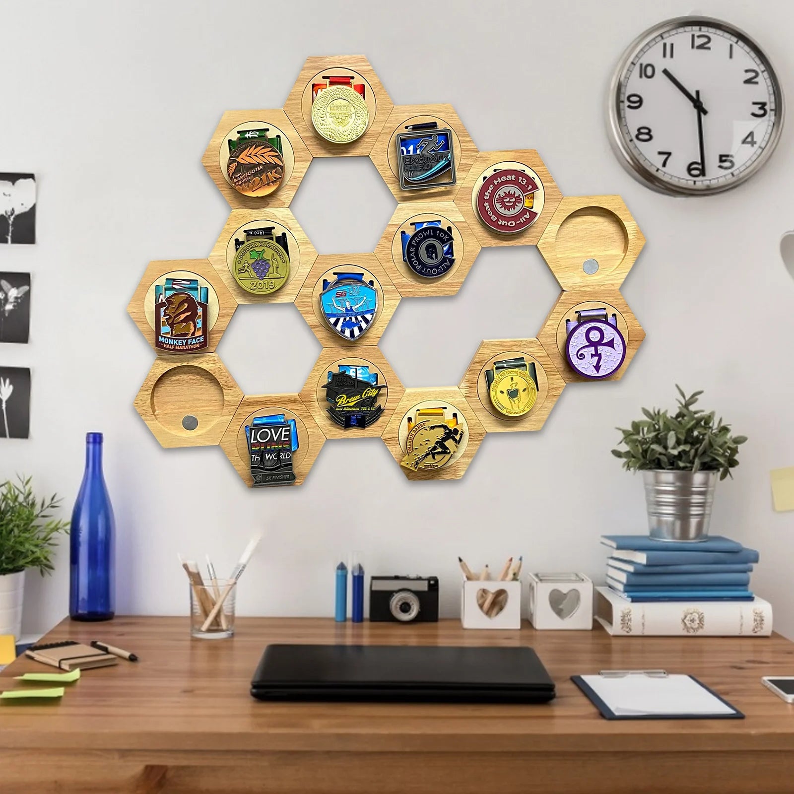 Étagère murale hexagonale en bois Nesty - Nid d'abeille, même assemblage d'hexagones sur un mur blanc près d'une horloge