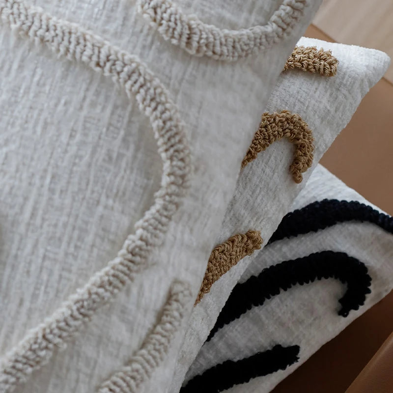 Housse de coussin en chénille tuftée, lignes simples Nesty, gros plan sur la texture tuftée en points beige et noir de deux housses en chénille