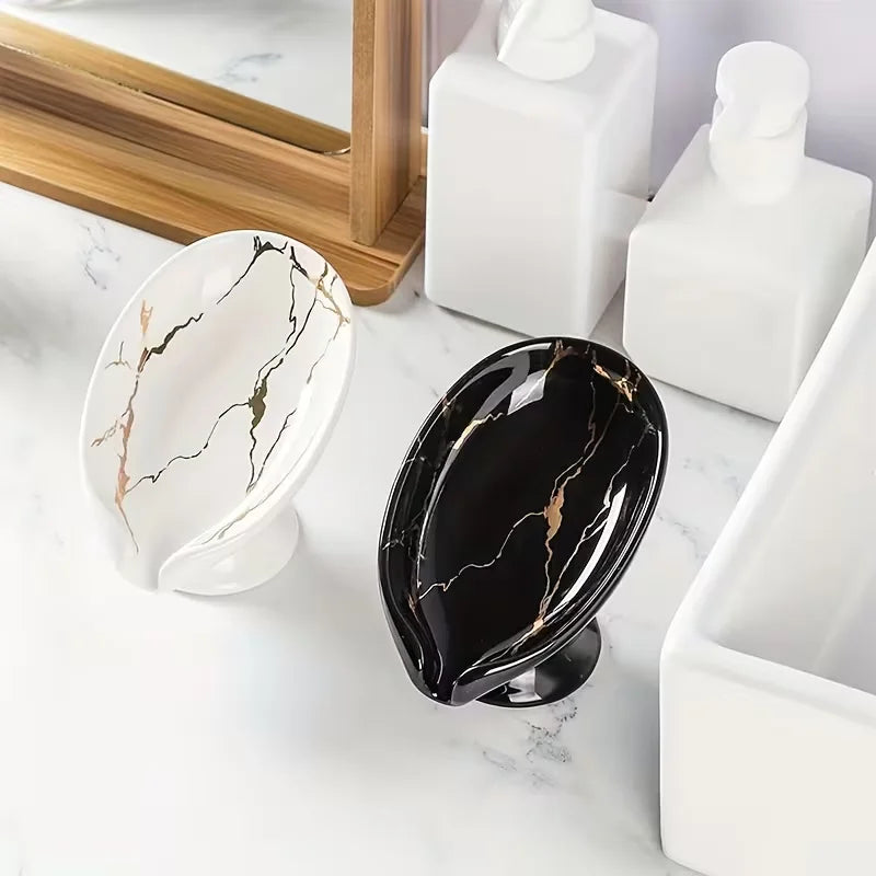 Duo de porte-savons en céramique effet marbre blanc et noir doré, posés sur un plan en marbre près d'un miroir en bois - Nesty