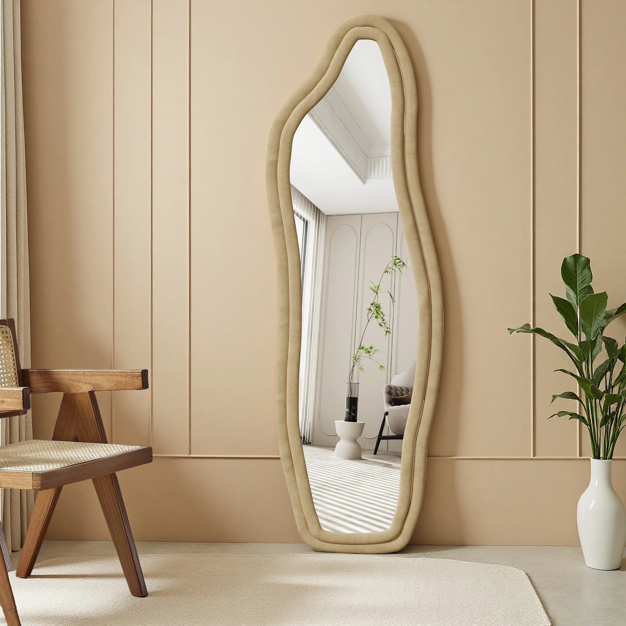 Miroir mural ondulé Nesty - Cadre écru sur mur beige, près d'une chaise en bois cannée et d'un vase