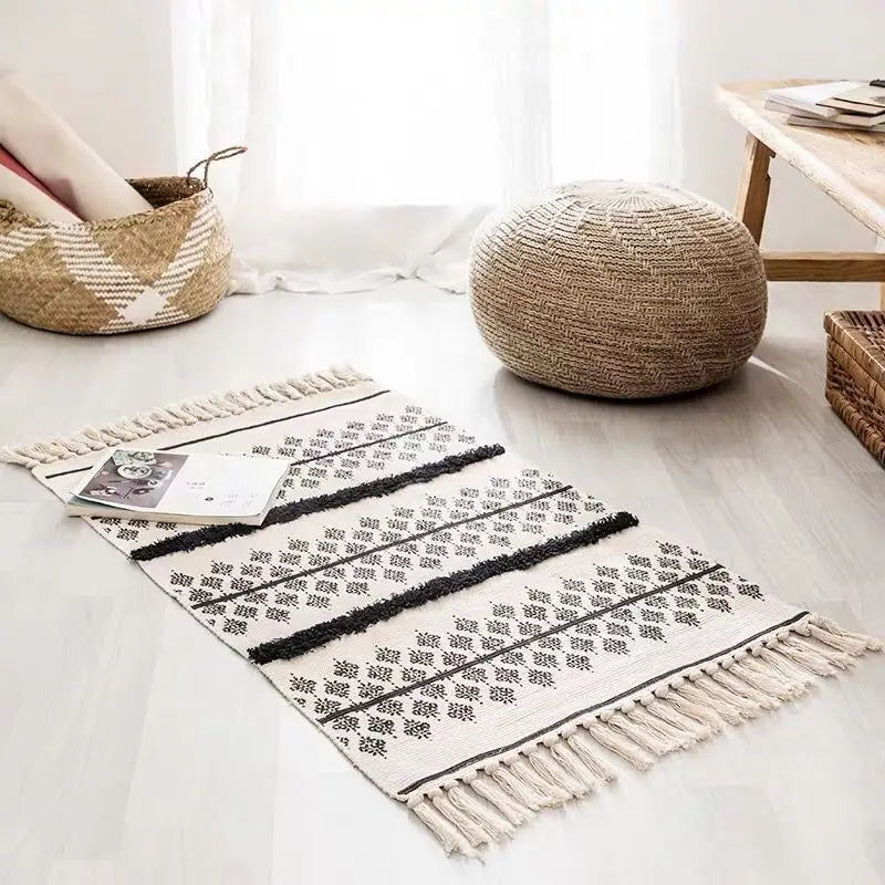 Tapis tissé main à franges — esprit bohème - Nesty, tapis écru à motif triangles pointillés noirs et franges, dans un salon avec pouf en jute
