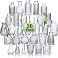 Set de mini vases en verre transparent, motif en relief - Nesty - Trente vases miniatures en verre transparent aux motifs variés (cannelé, quadrillé, ajouré), présentation en pyramide avec deux tulipes roses dans les vases centraux
