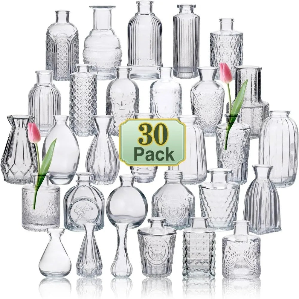 Set de mini vases en verre transparent, motif en relief - Nesty - Trente vases miniatures en verre transparent aux motifs variés (cannelé, quadrillé, ajouré), présentation en pyramide avec deux tulipes roses dans les vases centraux
