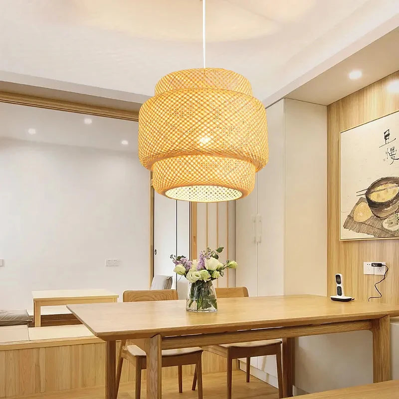Suspension en bambou tressé Nesty - Luminaire suspendu au-dessus d'une table à manger en bois avec bouquet de fleurs