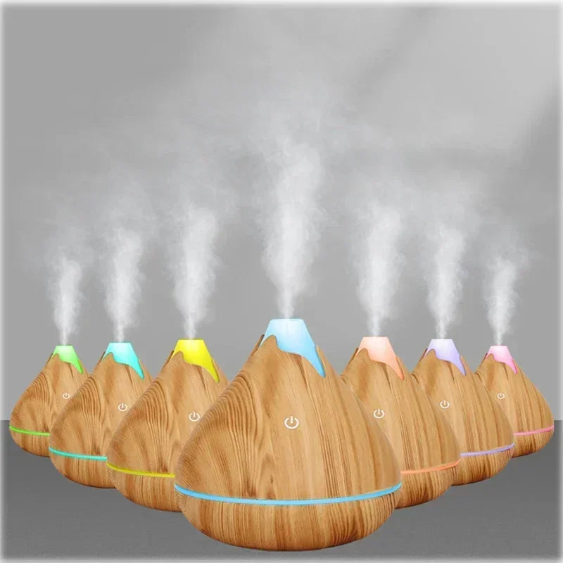 Diffuseur d'huiles essentielles en bois Nesty - Sept diffuseurs alignés avec halos de couleurs différentes