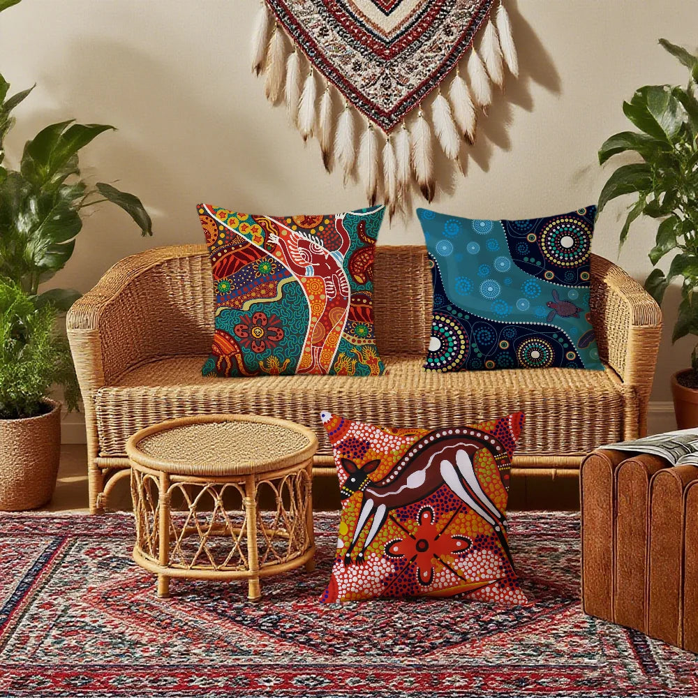 Housse de coussin à motifs ethniques, avec fermeture éclair Nesty, trois housses à motifs ethniques sur banquette en rotin devant tenture à plumes, coussin animal posé sur table basse