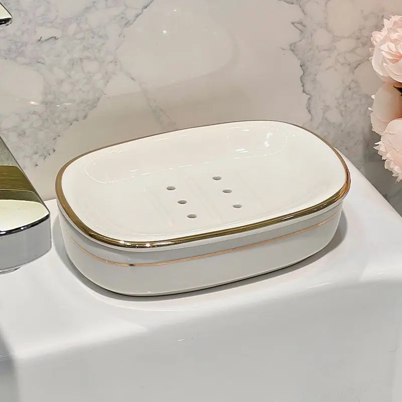 Porte-savon ovale en céramique blanc et or à trous d'égouttage, gros plan sur le rebord doré - Nesty