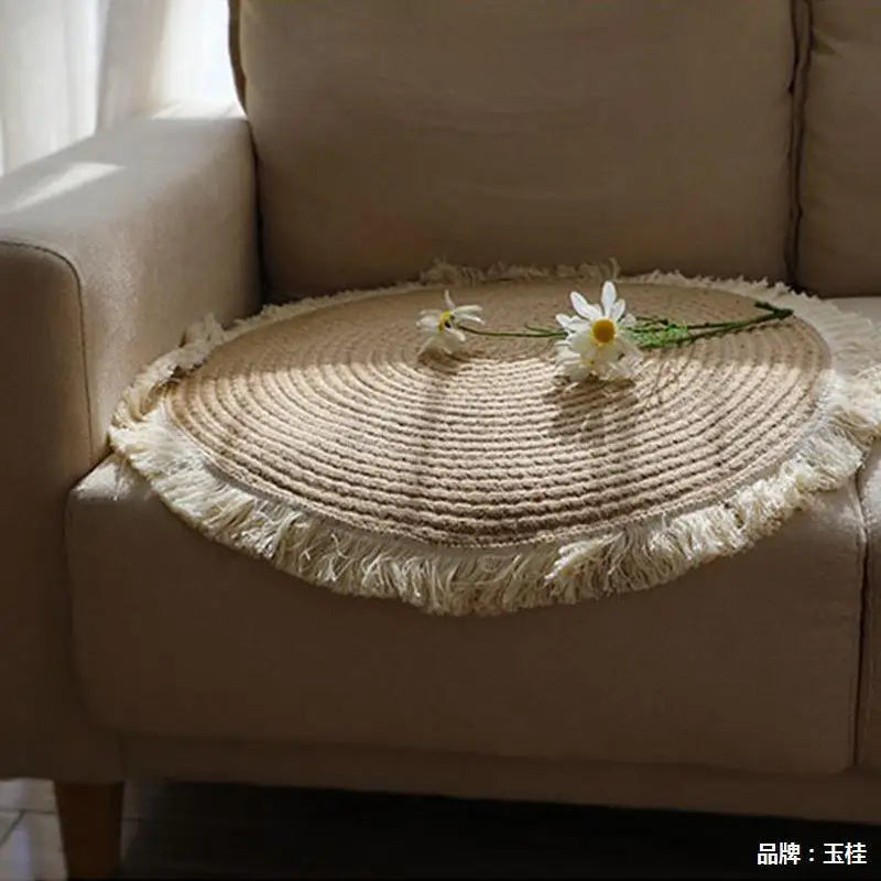 Tapis rond tressé en jute posé sur l'assise d'un fauteuil beige, avec des marguerites - Nesty