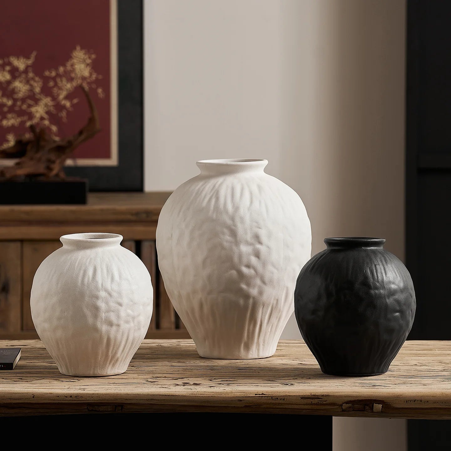 Vase en céramique noir et blanc, esprit wabi-sabi pour fleurs séchées Nesty, trois tailles groupées, deux blanches et une noire, sur la table en bois