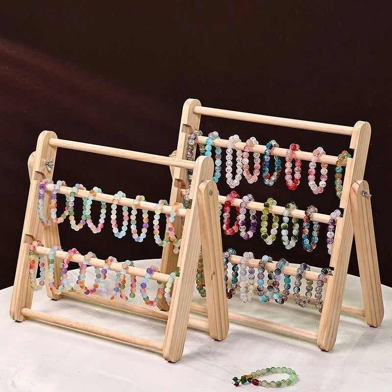 Présentoir en bois pour boucles d'oreilles et bijoux Nesty - Deux présentoirs avec bracelets de perles colorées sur fond sombre