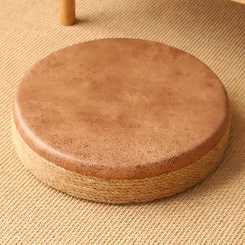 Tabouret bas en corde de chanvre, esprit tatami fait main Nesty, gros plan sur un tabouret rond à assise en cuir brun vieilli et base en corde de chanvre tressée