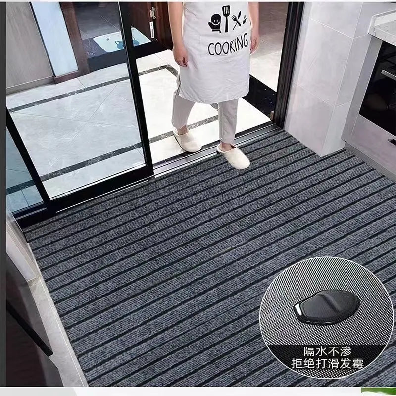 Tapis de cuisine en rouleau à rayures - Nesty, tapis gris à rayures posé à l'entrée d'une cuisine, personne en tablier de cuisine à proximité