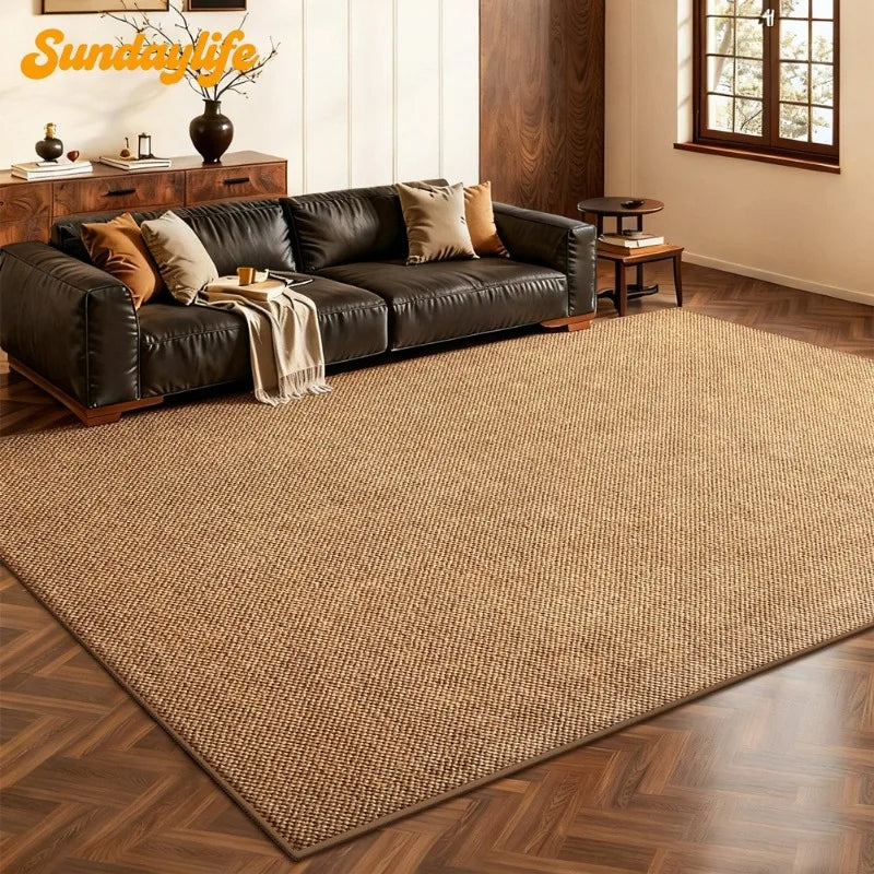 Grand tapis effet sisal marron tressé dans un salon, devant un canapé en cuir noir et un buffet en bois - Nesty