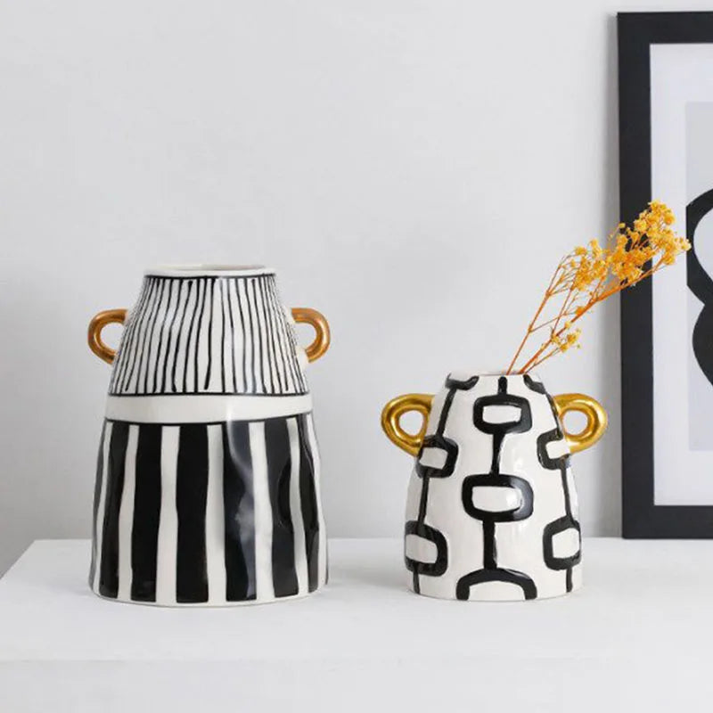 Vase en céramique rayé — silhouette abstraite haute - Nesty - Les deux vases avec brins de fleurs séchées jaunes dans le petit modèle, devant un cadre encadré