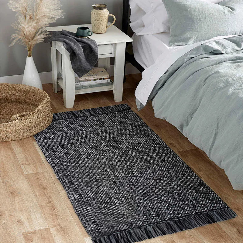 Tapis en coton et lin à rayures — style nordique - Nesty, coloris noir et blanc chevrons à franges, au pied d'un lit